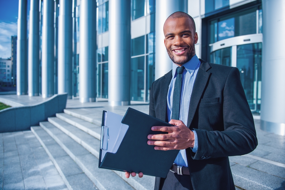 Handsome,Young,Businessman,In,Classic,Suit,Holding,A,Folder,,Looking